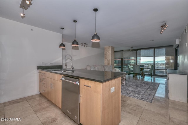 kitchen with decorative light fixtures, kitchen peninsula, sink, expansive windows, and light brown cabinets