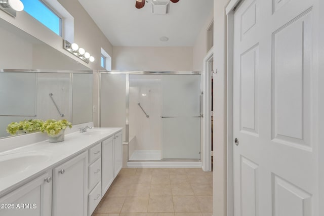 full bath with double vanity, a shower stall, ceiling fan, and tile patterned floors