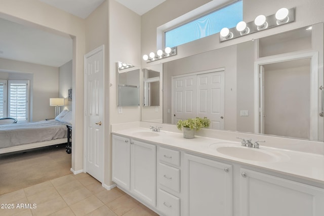 ensuite bathroom featuring double vanity, a sink, ensuite bath, and tile patterned floors