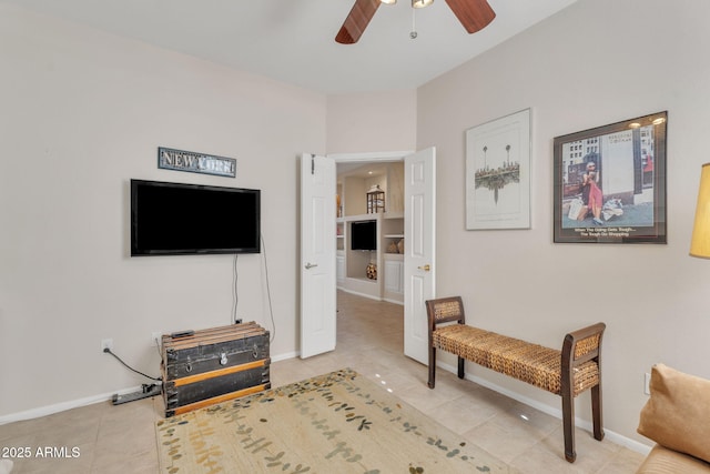 sitting room featuring baseboards, a ceiling fan, and light tile patterned flooring