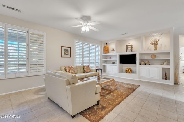 living area featuring built in features, visible vents, and light tile patterned flooring