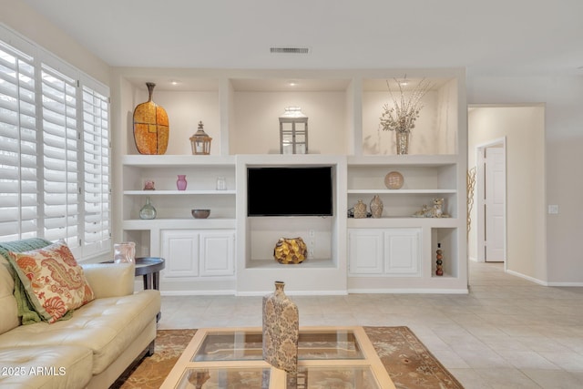 living room with baseboards, built in shelves, visible vents, and tile patterned floors