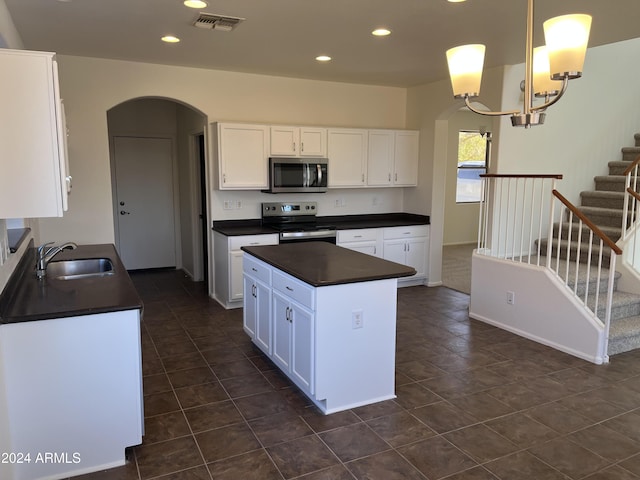 kitchen featuring white cabinets, pendant lighting, stainless steel appliances, and sink