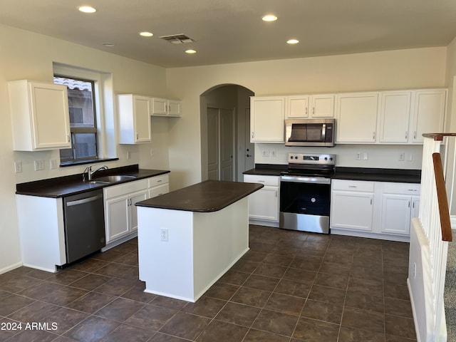 kitchen with a center island, white cabinetry, sink, and appliances with stainless steel finishes