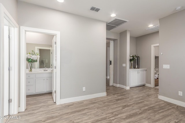 hallway with light hardwood / wood-style floors and sink