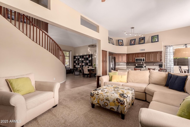 1453 E Elgin Pl, Chandler, AZ 85225 - living area featuring a chandelier, a high ceiling, rail lighting, tile patterned flooring, and carpet floors