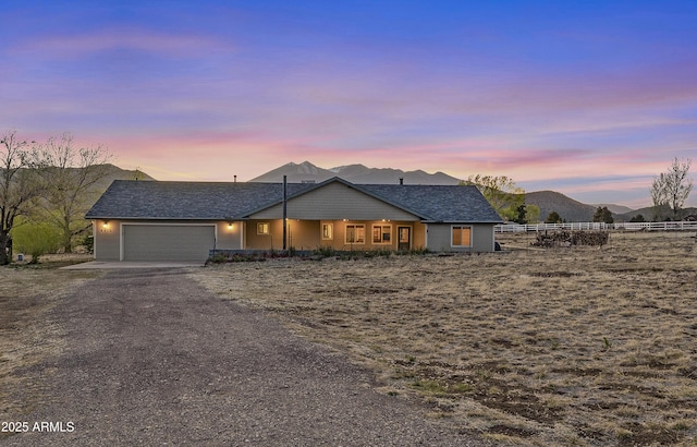 ranch-style home featuring driveway, an attached garage, and fence