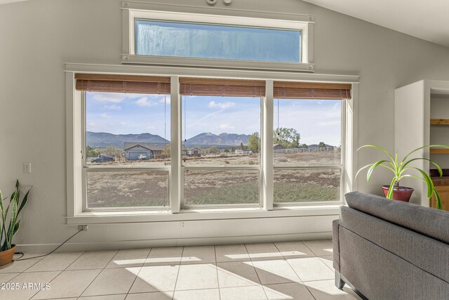 interior space with light tile patterned floors, a mountain view, and vaulted ceiling