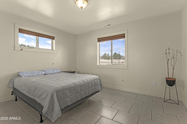 bedroom featuring light tile patterned flooring, visible vents, and baseboards