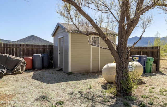 view of shed with a mountain view and fence