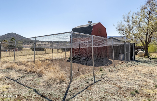 view of barn featuring fence and a mountain view