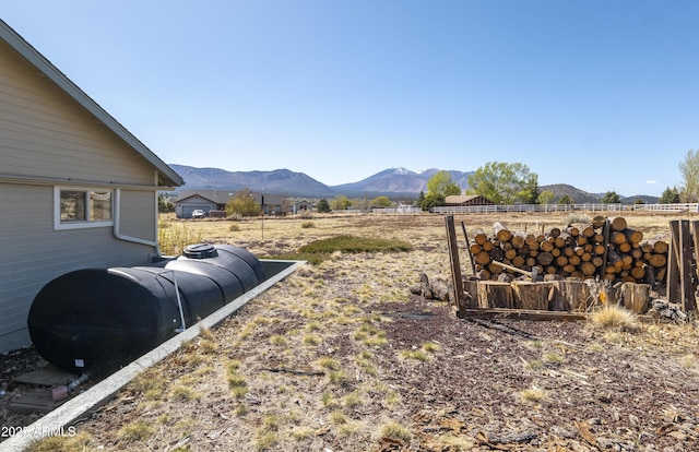 view of yard featuring fence and a mountain view