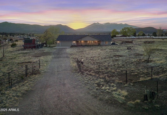 view of road with a mountain view, dirt driveway, and a gated entry