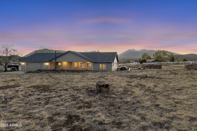 exterior space featuring fence, a mountain view, and an attached garage