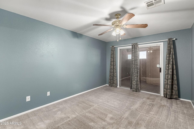 carpeted spare room with a ceiling fan, visible vents, and baseboards