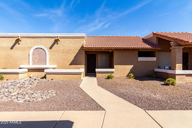 view of front of house with a tiled roof and stucco siding