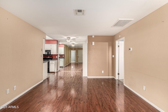 unfurnished living room with dark wood-type flooring, visible vents, ceiling fan, and baseboards