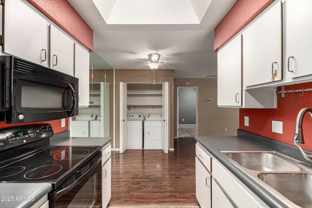 kitchen featuring a sink, black appliances, white cabinetry, and washer and dryer