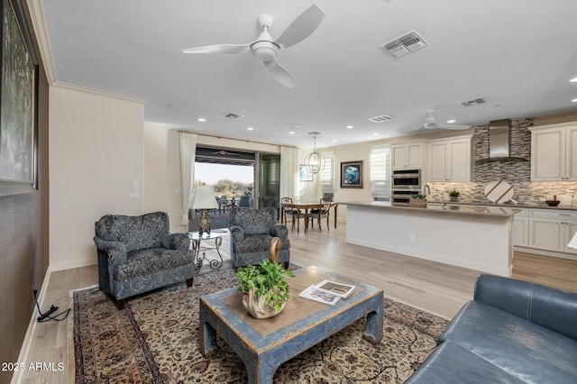 living room with ceiling fan and light wood-type flooring