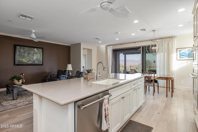 kitchen featuring dishwasher, sink, white cabinets, ceiling fan, and a center island with sink