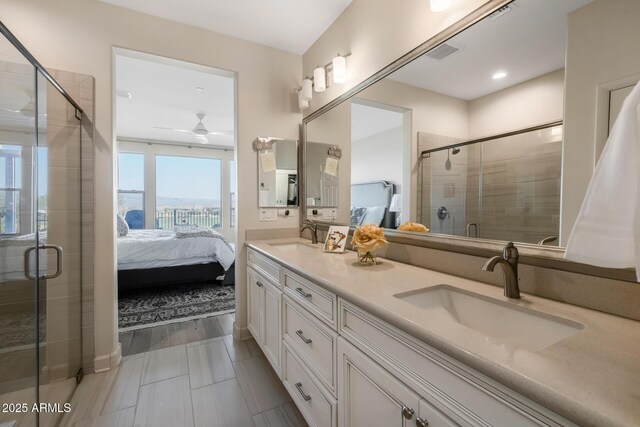 bathroom with vanity, a shower with door, and ceiling fan