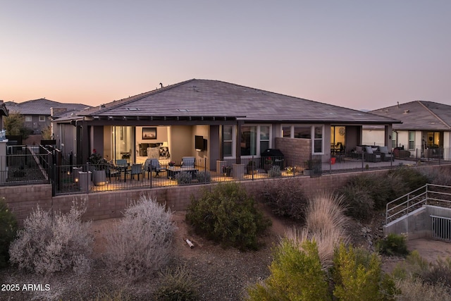 back house at dusk with a patio