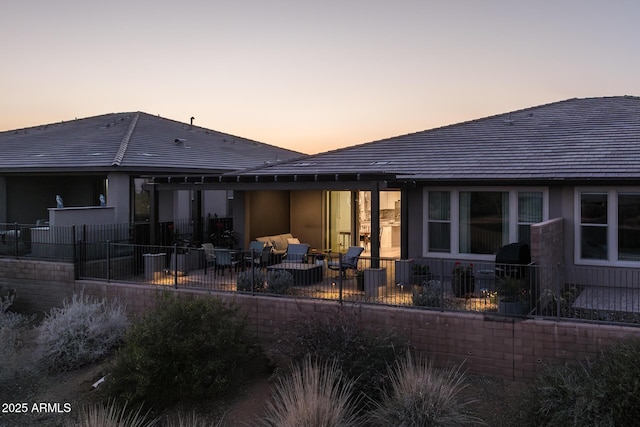 back house at dusk with a patio