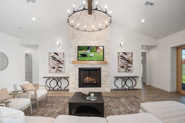 living room with a chandelier, vaulted ceiling, a fireplace, and wood-type flooring