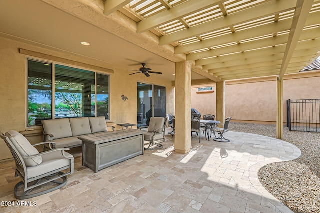 view of patio / terrace with ceiling fan, an outdoor living space with a fire pit, and a pergola