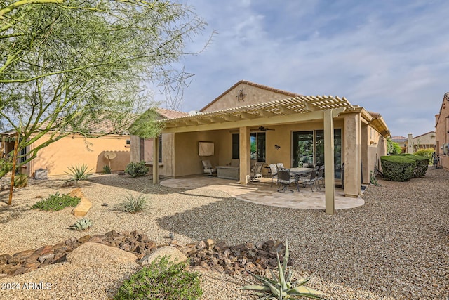 rear view of house with ceiling fan and a patio