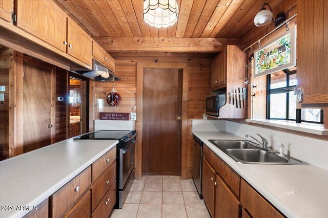 kitchen with wood ceiling, wood walls, sink, light tile patterned flooring, and range with electric stovetop