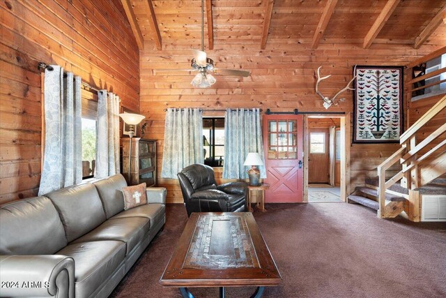 unfurnished living room with ceiling fan, wood ceiling, high vaulted ceiling, wood walls, and carpet floors