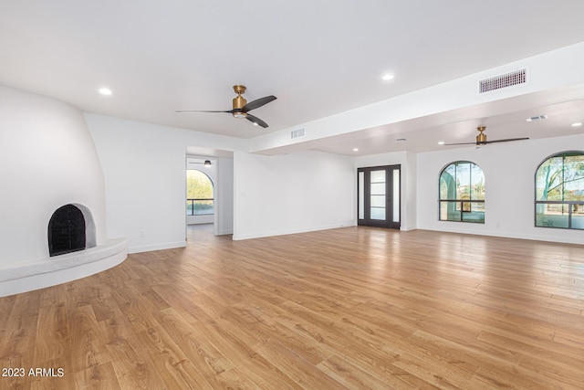 unfurnished living room with ceiling fan and light hardwood / wood-style floors