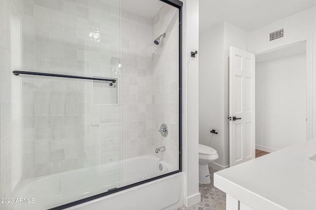 bathroom with combined bath / shower with glass door and toilet