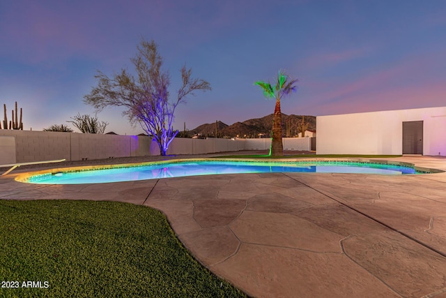 pool at dusk featuring a patio area