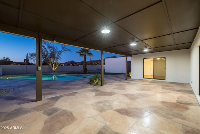 patio terrace at dusk featuring a fenced in pool