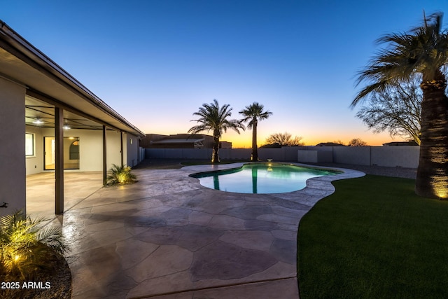 pool at dusk featuring a patio