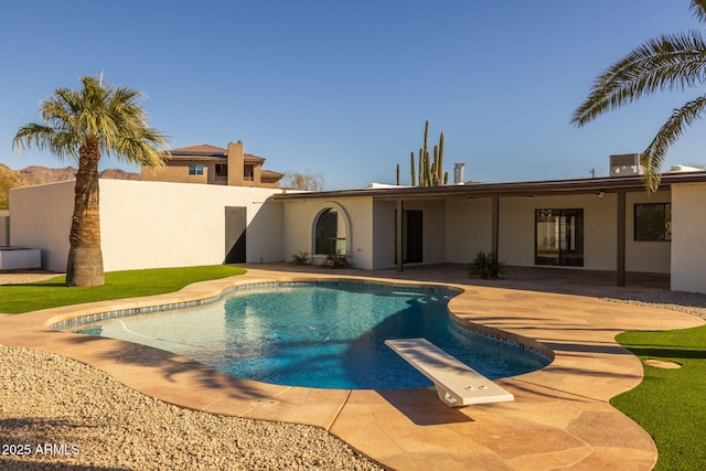 view of pool featuring a diving board and a patio