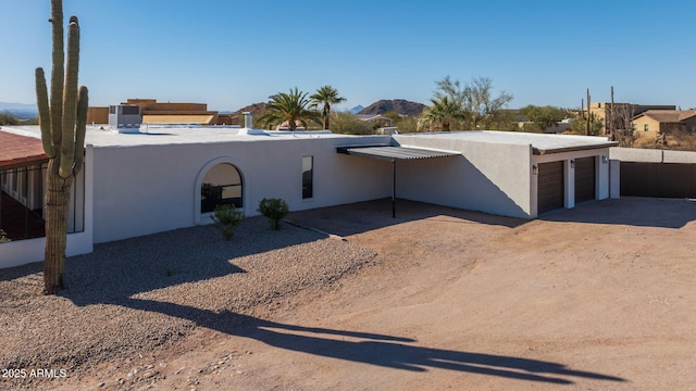 view of front facade featuring a mountain view, cooling unit, and a garage