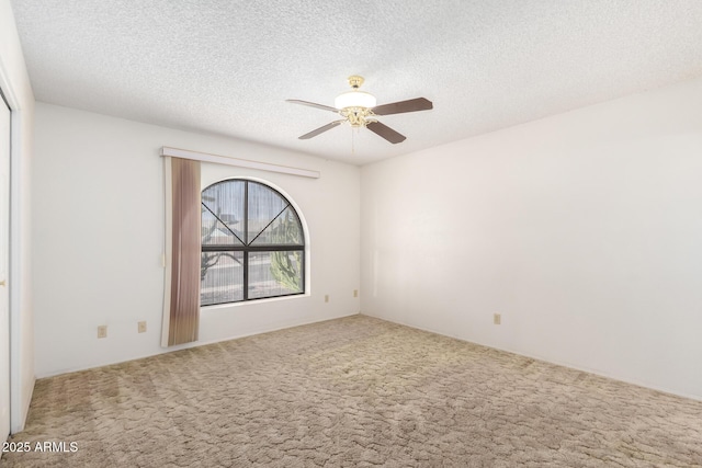 carpeted spare room featuring ceiling fan and a textured ceiling