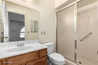 full bath featuring vanity, a shower stall, and toilet