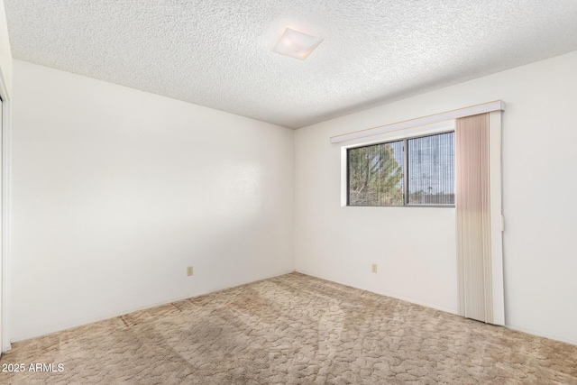 unfurnished room with a textured ceiling and carpet flooring