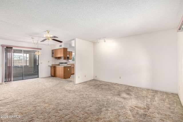 unfurnished living room with light carpet, a textured ceiling, track lighting, and a ceiling fan