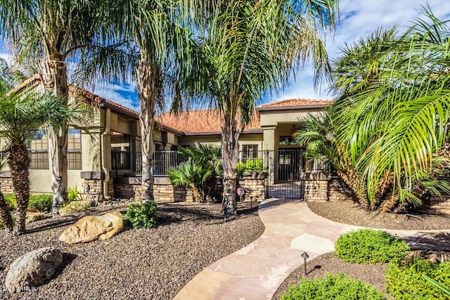 16446 N 59th St, Scottsdale, AZ 85254 - view of front of house featuring stucco siding, a gate, stone siding, fence, and a tiled roof