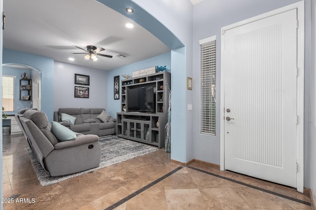 13629 W San Miguel Ave, Litchfield Park, AZ 85340 - living room featuring arched walkways, a ceiling fan, baseboards, recessed lighting, and light stone finish floors