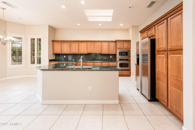 kitchen featuring visible vents, a sink, stainless steel appliances, backsplash, and light tile patterned flooring