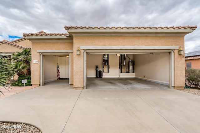 garage featuring concrete driveway and gas water heater