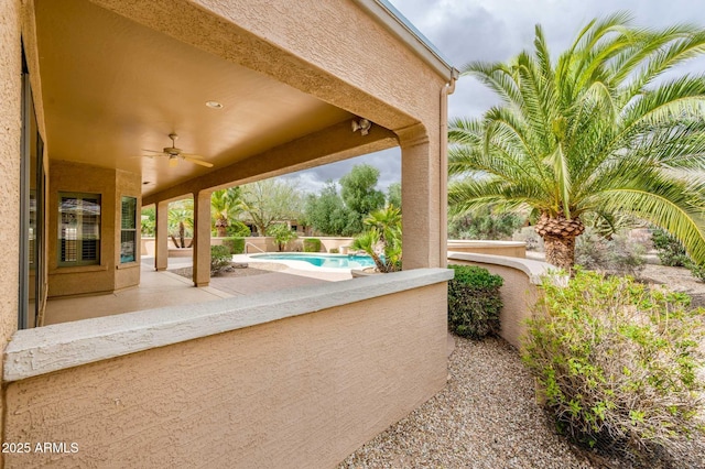 view of patio / terrace with ceiling fan and a fenced in pool