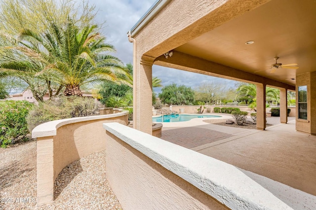 view of patio / terrace with ceiling fan and a fenced in pool