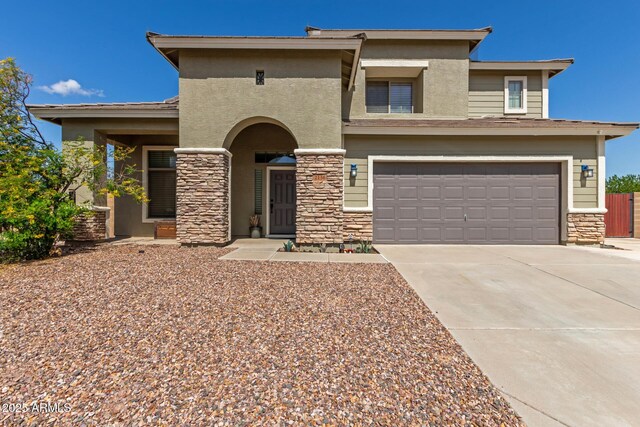 view of front facade with stone siding, an attached garage, stucco siding, and driveway